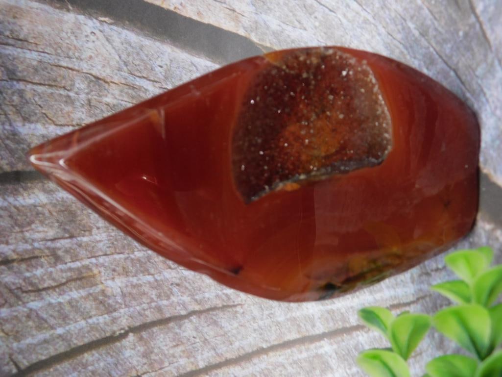Polished Carnelian Agate Slice with Crystal Formation: Polished carnelian agate slice featuring natural crystal formations in the center. Deep reddish-brown tones with semi-translucent areas. Measures 126 grams in weight and includes unique textural featu