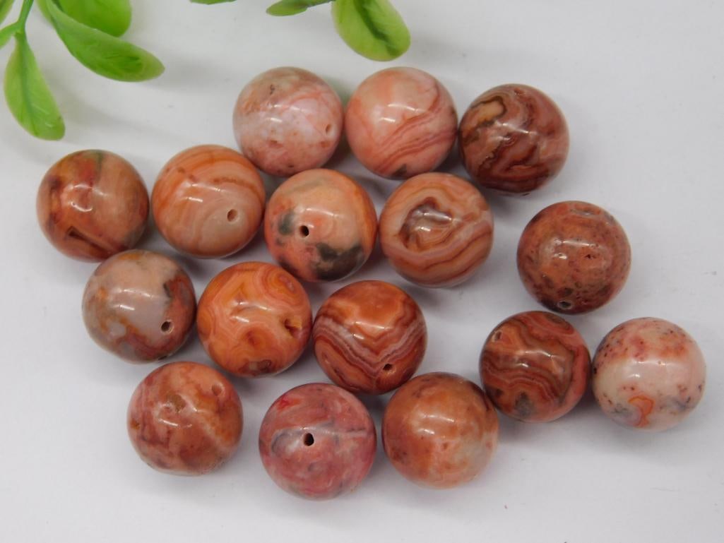 Set of Polished Red Agate Beads With Drilled Holes: This lot includes a set of red agate beads, polished to a smooth finish. Each bead features a drilled hole for use in crafting or jewelry making. The beads display natural patterns and a range of redd