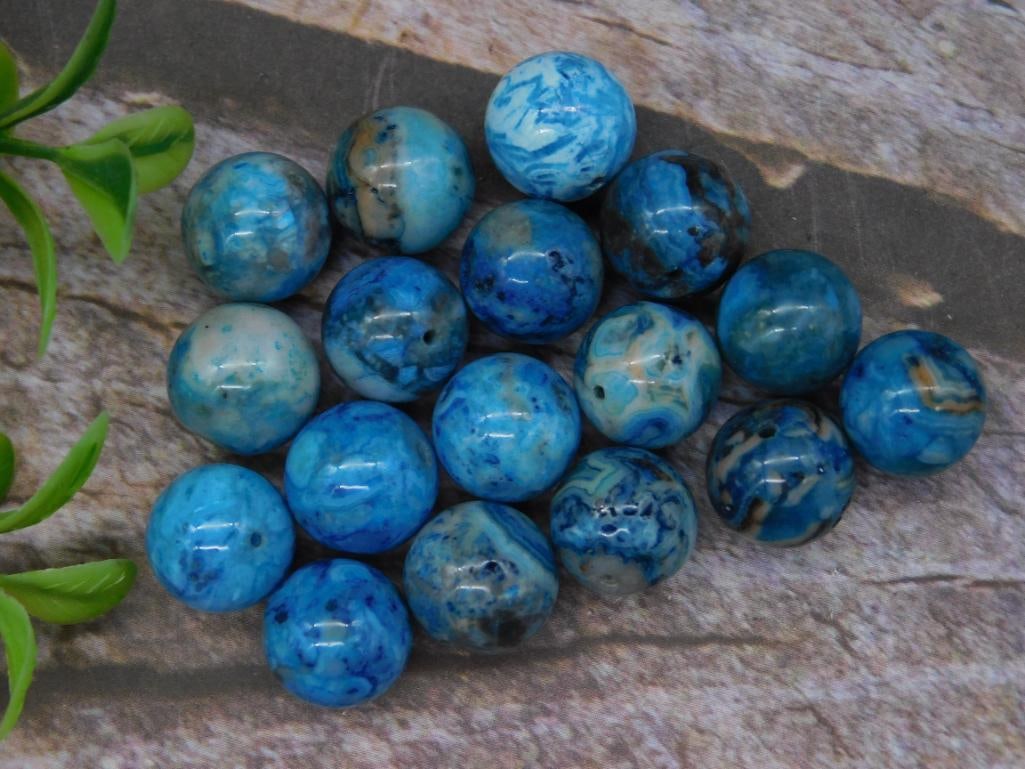 Lot of Blue and White Beads for Jewelry Making: This lot includes 18 approximately spherical beads in blue and white hues with swirling patterns. Suitable for crafting, they feature pre-drilled holes, making them ideal for stringing in jewelry. The