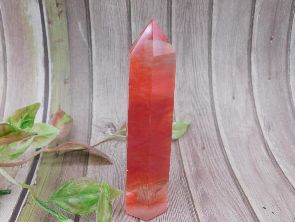 Red and Orange Crystal Obelisk Tower: This red and orange crystal obelisk features a polished surface with a pointed tip. It includes natural color variations and internal patterns that enhance its unique appearance. Approximate size is s