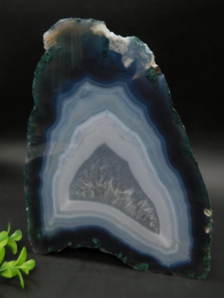 Polished Blue Agate Display: This polished agate slice features natural banding with a range of blue and gray tones. The slice displays intricate patterns and translucent layers, making it ideal for display or study. Includes a r