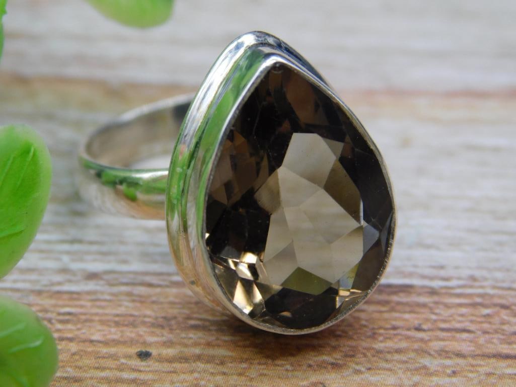 Smokey Quartz Sterling Silver Ring: A sterling silver ring featuring a pear-shaped smokey quartz gemstone. The band is stamped with '925,' indicating genuine sterling silver. Ring size and weight clearly displayed in the images. Ideal f