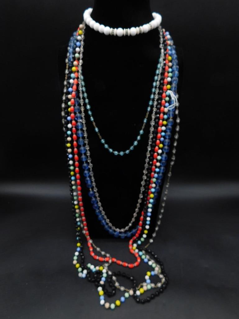 Assorted Beaded Necklaces and White Bead Choker: This lot features a collection of assorted beaded necklaces in various colors and designs, with beads ranging from clear and translucent to opaque multicolored. Includes one white bead choker necklace