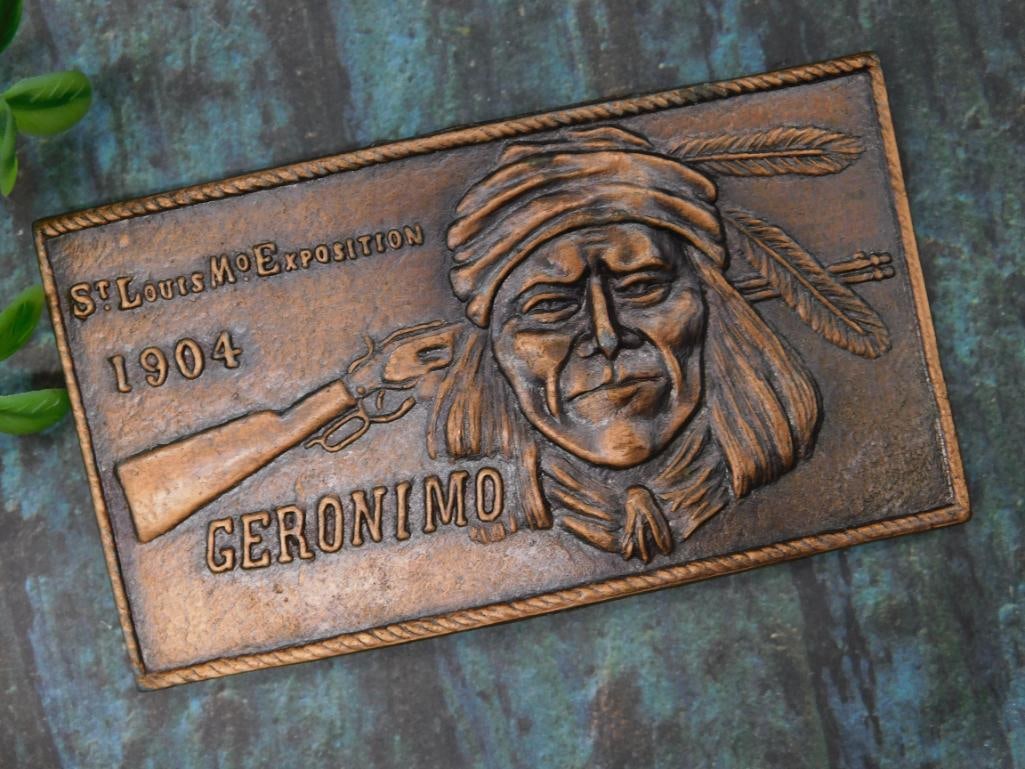 1904 Geronimo St. Louis Exposition Brass Belt Buckle: Rectangular brass belt buckle commemorating the 1904 St. Louis Exposition, featuring an engraved portrait of Geronimo with a rifle depicted alongside. Includes an integrated loop and latch mechanism o