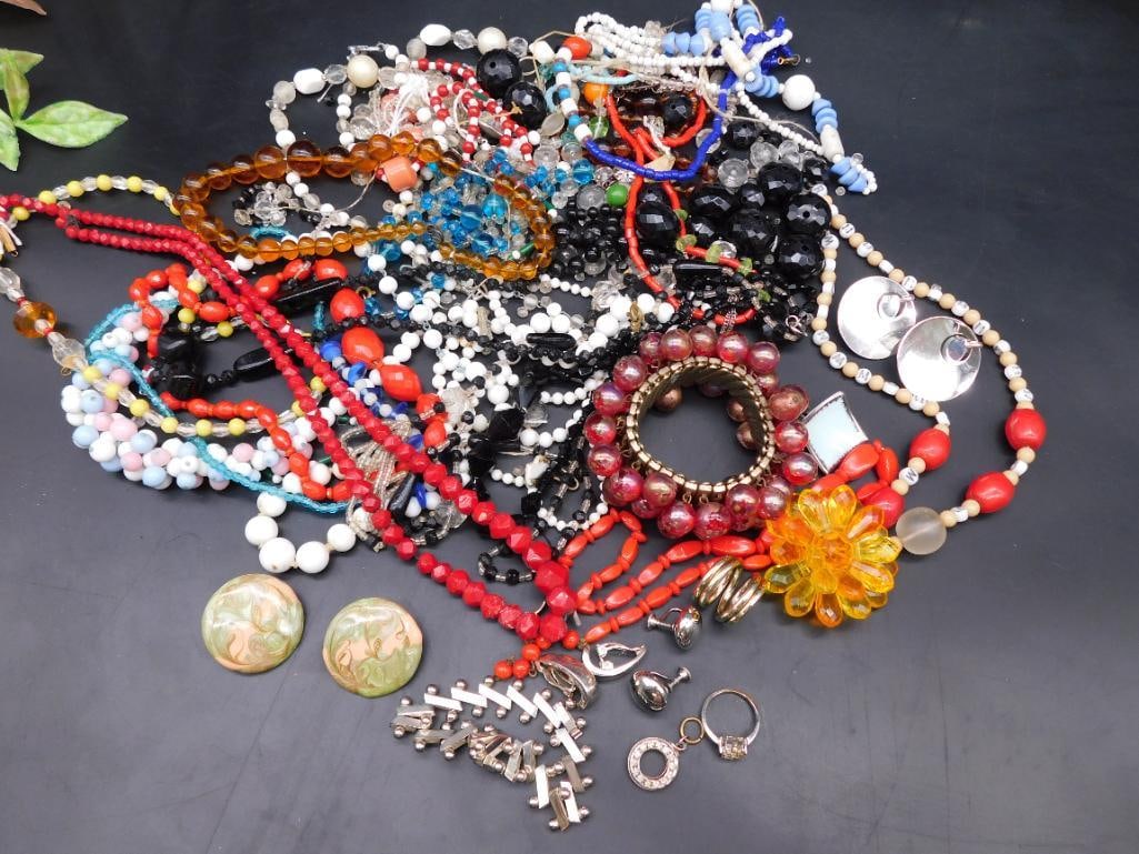 Collection of Costume Jewelry Including Necklaces and Accessories: Assorted collection of costume jewelry including multi-color beaded necklaces, bracelets, earrings, and brooches. Includes various materials such as plastic, metal, and resin. Some items feature flora