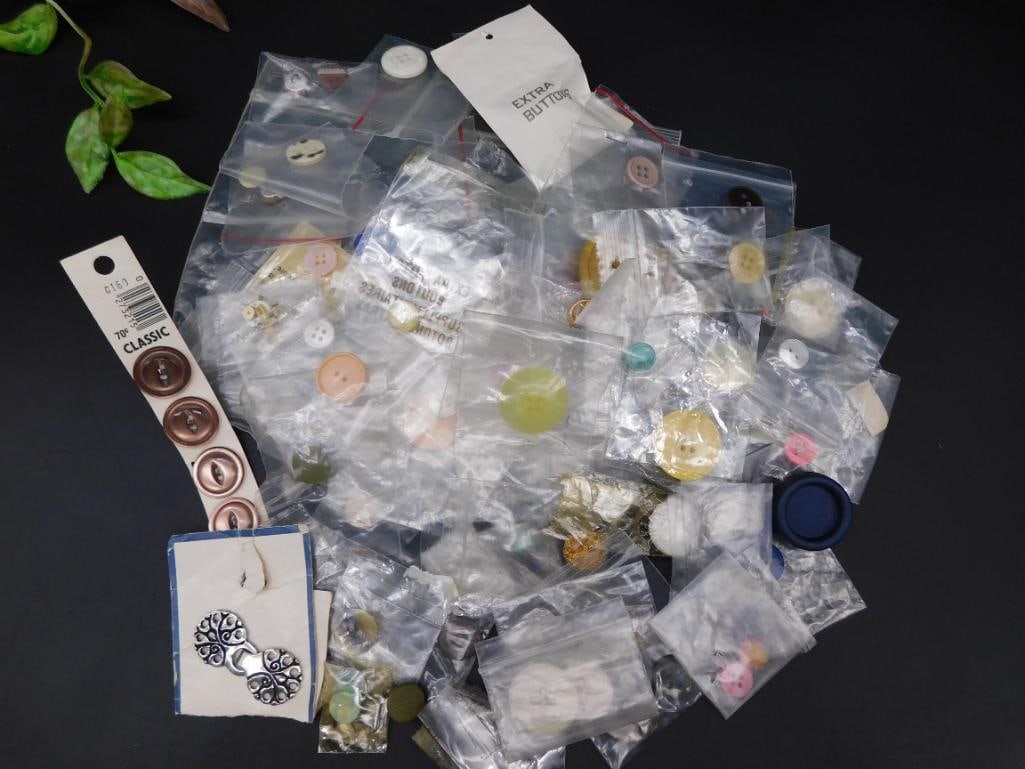 Large Assorted Lot of Mixed Buttons and Fasteners: This auction offers a large mixture of buttons and fasteners, including single and grouped sets, all contained in individual plastic bags. Various materials and colors are present, ideal for crafting 