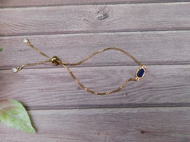 Gold-Tone Bracelet With Adjustable Chain and Blue Oval Stone