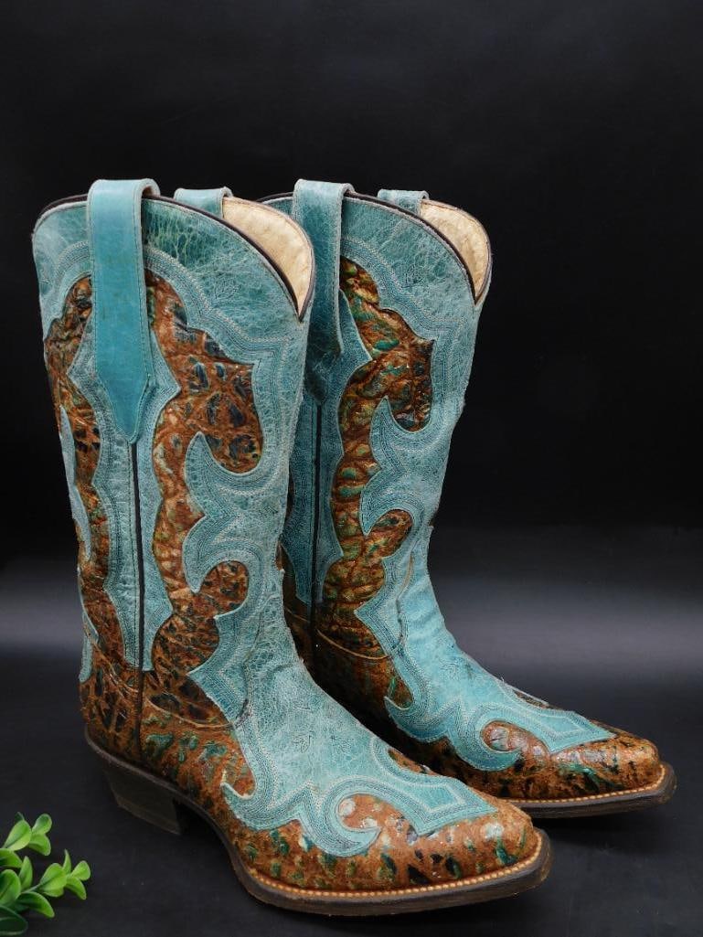 Teal and Brown Leather Cowboy Boots, Size 7M: Pair of leather cowboy boots featuring a teal and brown design with detailed stitching and embossed patterns. Marked "USA Stock Last Reg No. Co. 131 1524" with a size of 7M. Soles show signs of wear b