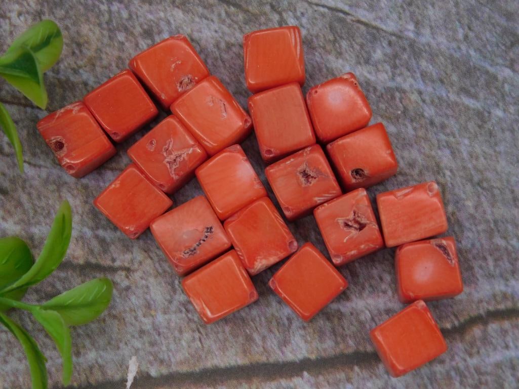 Collection of Red Coral Beads, Square Shape: A lot of red coral square-shaped beads, totaling approximately 30 grams. The beads display natural imperfections and vary slightly in size and texture. Ideal for crafting or jewelry-making purposes.