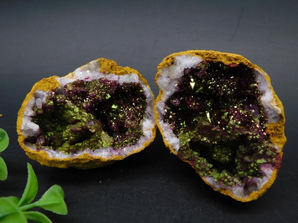 GEODE ROCK STONE LAPIDARY SPECIMEN: This item is a geode split into two halves with a gold-tone outer crust. The interiors feature a vibrant combination of amethyst and green druzy quartz crystals. Each half is distinctly textured, show