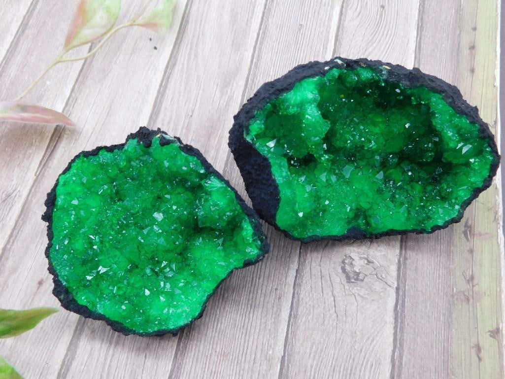Green Crystal Geode Cluster Specimen Split Pair: This auction features a split pair of green crystal geodes with a vibrant crystalline formation. Each piece shows detailed mineral crystallization on the interior and a rough outer surface. The total 