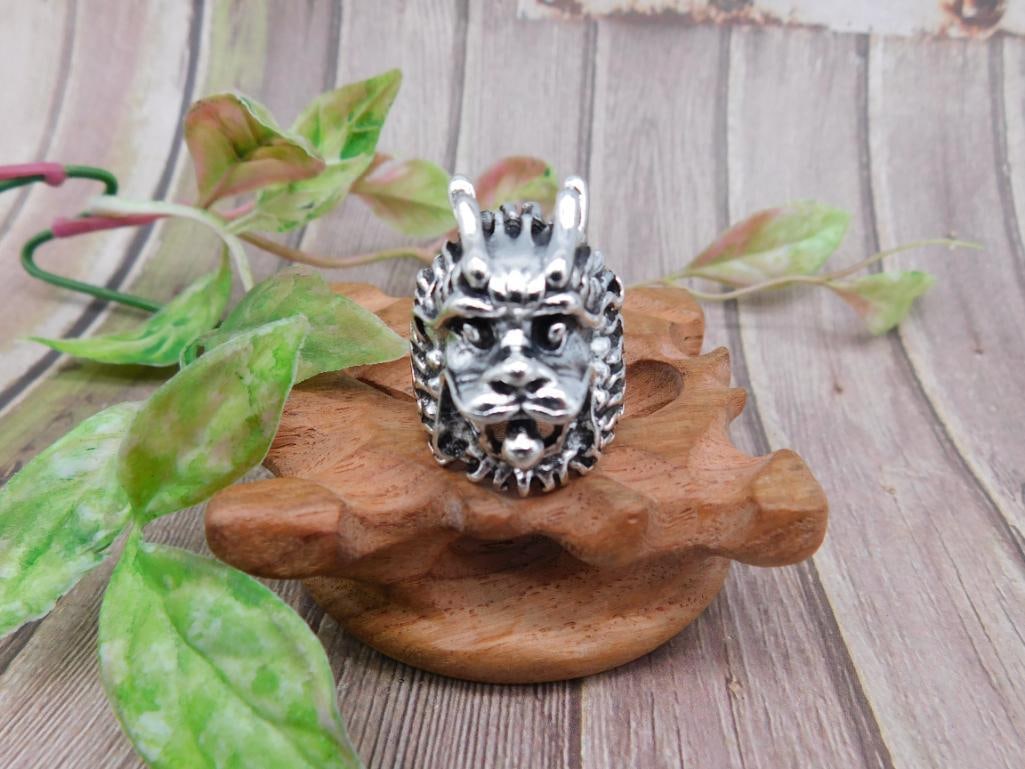 Silver-Tone Adjustable Lion Head Ring: Silver-tone lion head ring featuring detailed facial features and mane design. Adjustable band to fit various sizes. Constructed of metal alloy for durability. Ideal for jewelry collections or as a st