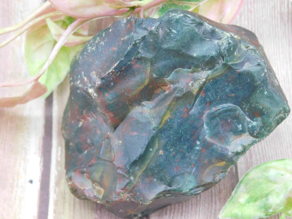Raw Green and Red Jasper Rock Specimen: A raw and unpolished green and red jasper specimen displaying a natural blend of green and red hues. Ideal for collectors, lapidary work, or decor. Presented alongside a ruler for size reference and a