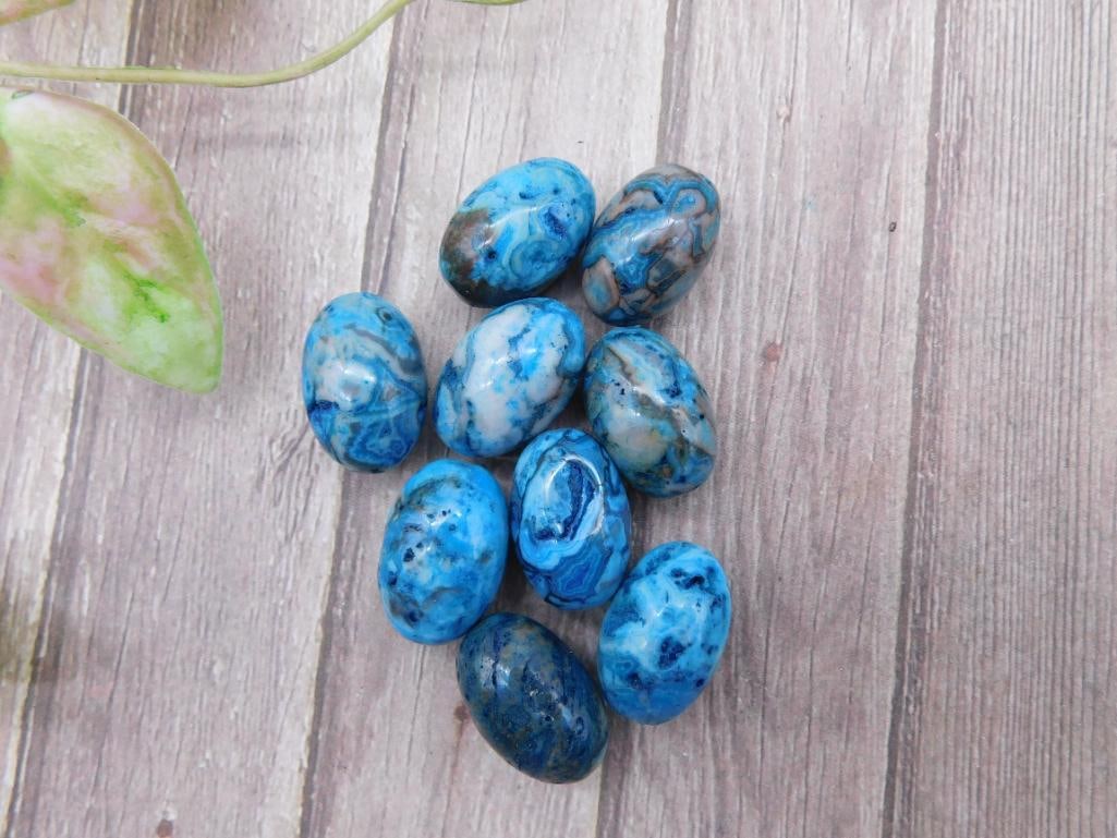 Collection of Blue Polished Stones for Auction: Set of 10 blue polished stones with marbled patterns, showcasing various shades and unique swirls. Stones appear to be oval-shaped and have a smooth finish, ideal for decorative or collection purposes