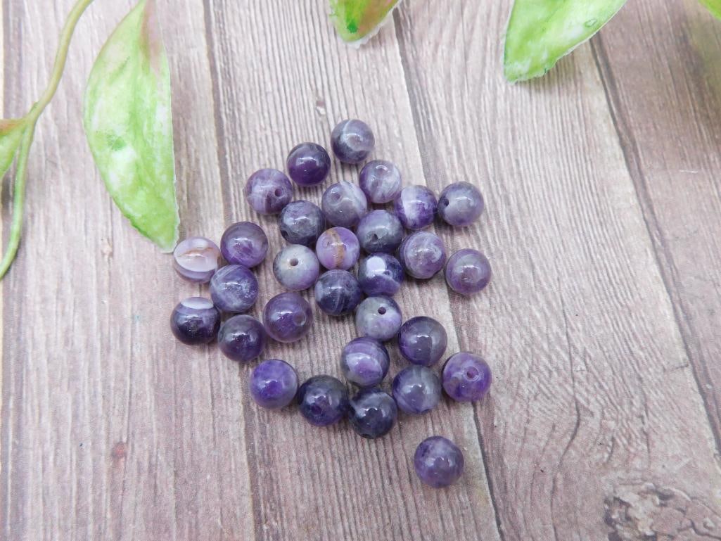 Lot of Purple Amethyst Beads for Jewelry Making: A collection of round amethyst beads, ideal for crafting, jewelry making, or decoration. The lot contains multiple beads, with visible drill holes for stringing purposes. Measured against a ruler for 
