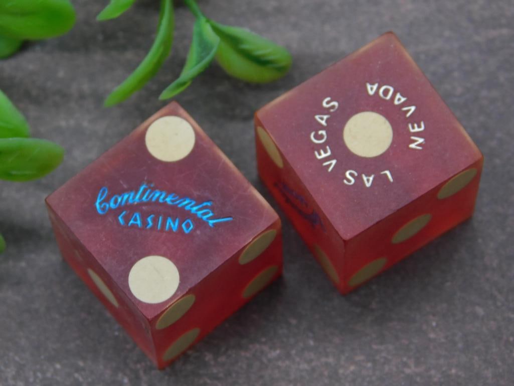 Continental Casino Red Dice Set from Las Vegas, Nevada: Set of two red dice from Continental Casino in Las Vegas, Nevada. Dice feature gold pips and emblems, with "Continental Casino" on one side and "Las Vegas Nevada" on the opposing side. Dice appear in 