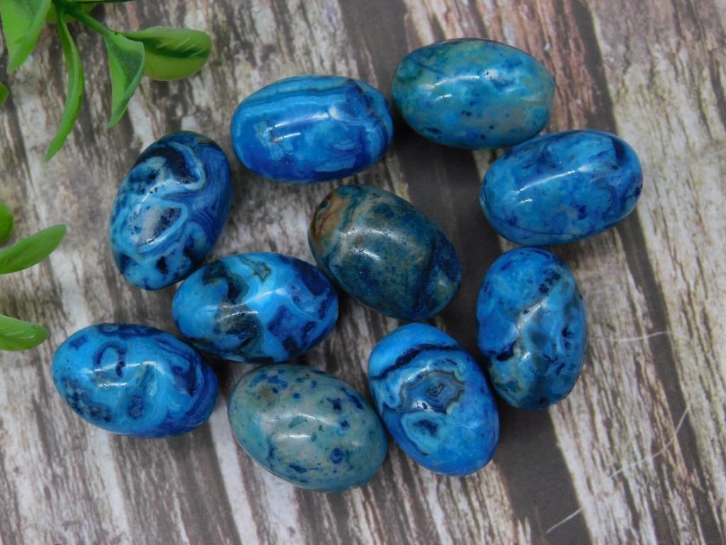 Set of Polished Blue Gemstone Beads: A set of ten polished blue gemstone beads with vibrant patterns and swirls. These beads are uniform in shape, each oval, as displayed in the provided collection. Weighs approximately 46 grams. Ideal f