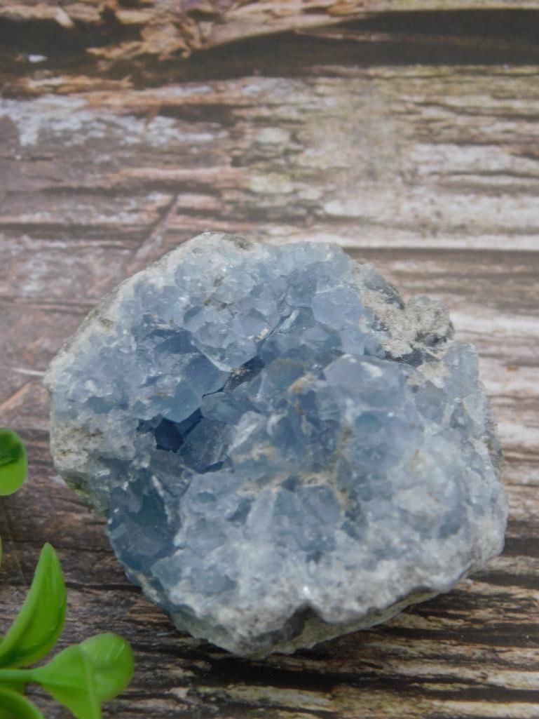 CELESTITE ROCK STONE LAPIDARY SPECIMEN: This lot features a Celestite geode mineral specimen with a striking blue crystal interior. Weighing 261 grams, this piece showcases a rough outer texture and polished natural crystals on the inside. 