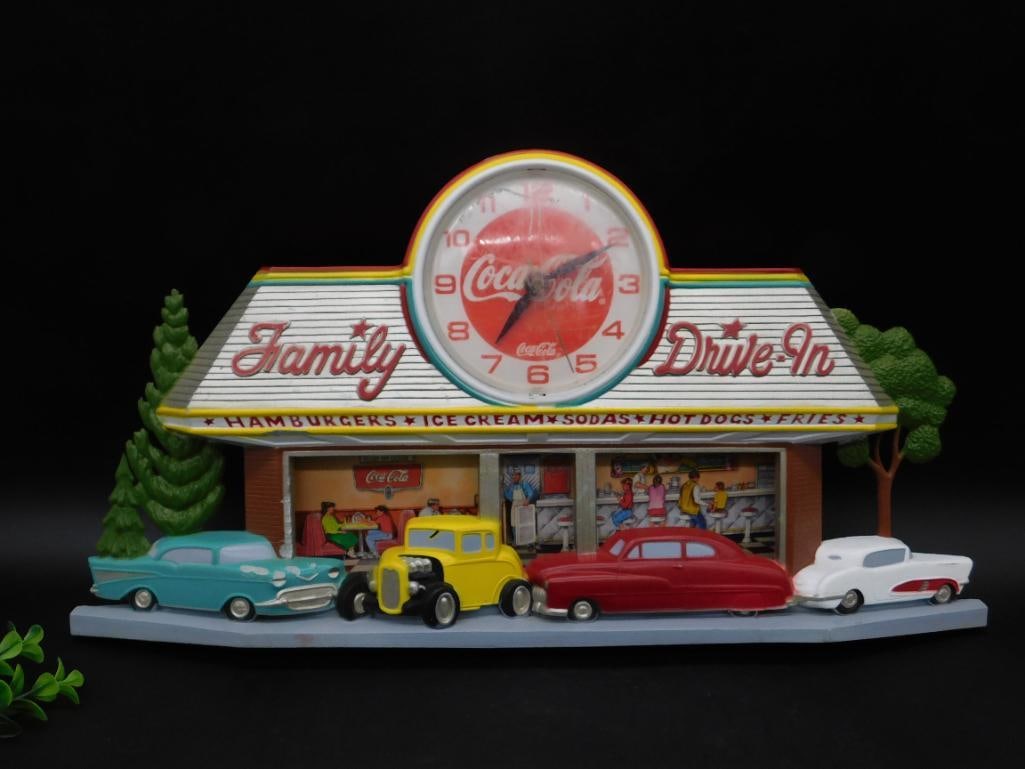 Coca-Cola Family Drive-In Theme Wall Clock by Burwood: Coca-Cola-themed wall clock featuring a vintage drive-in scene with cars. Produced by Burwood Products Co. in the USA, dated 1988. Includes a round Coca-Cola logo clock face, mounted above the drive-i