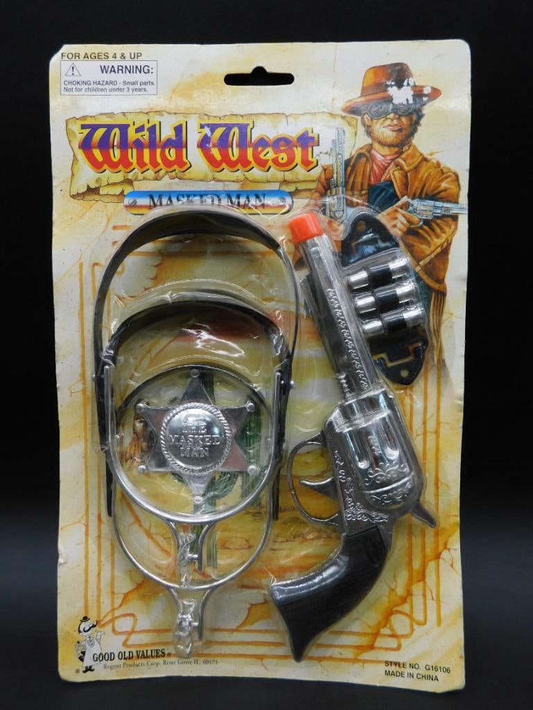 Wild West Toy Gun and Badge Set in Original Packaging: Wild West-themed toy set including a toy pistol with rotating barrel, a sheriff's badge, and additional accessories. The items are sealed in their original retail packaging, featuring Western imagery.