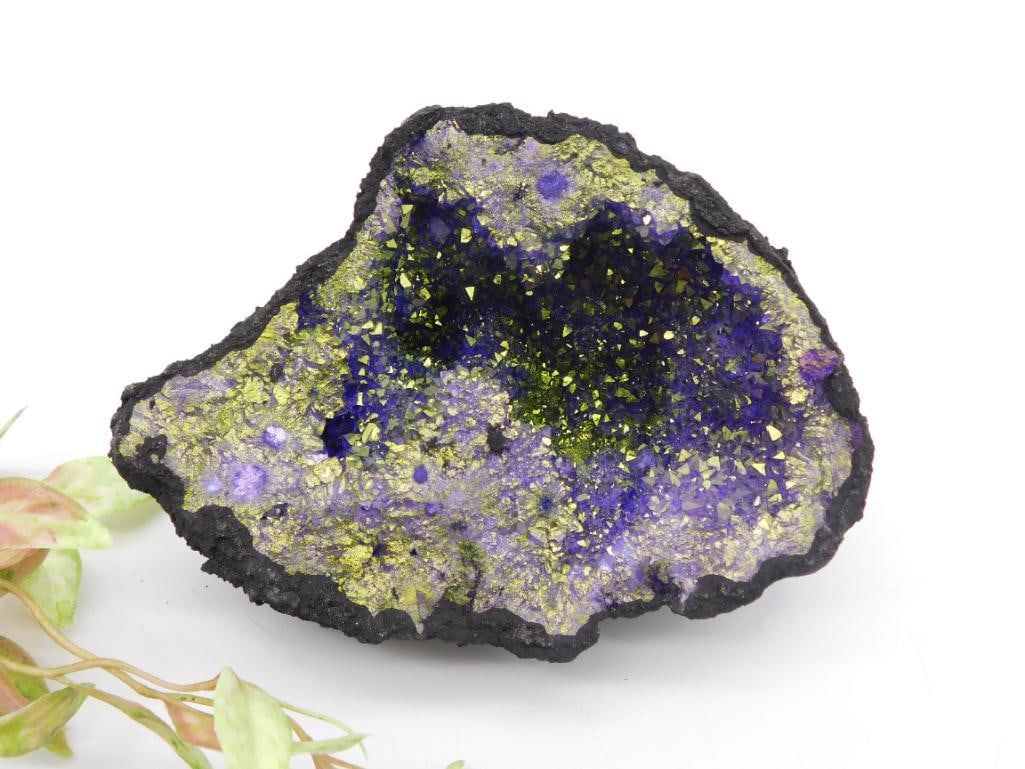 Purple and Gold Geode Specimen: This geode specimen features a vibrant display of purple and gold coloration, likely due to chalcopyrite and potentially other minerals. The rock formations exhibit a sparkling, crystal-like structure