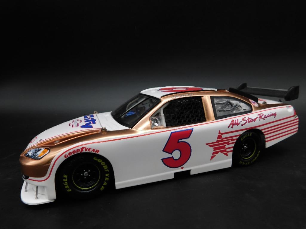 1:24 Scale Race Fans Collectible Stock Car NIB: 1:24 scale collectible stock car by Race Fans Collectibles. Features a white body with red and gold detailing and the number 5 prominently displayed. Includes original packaging with branding and prod