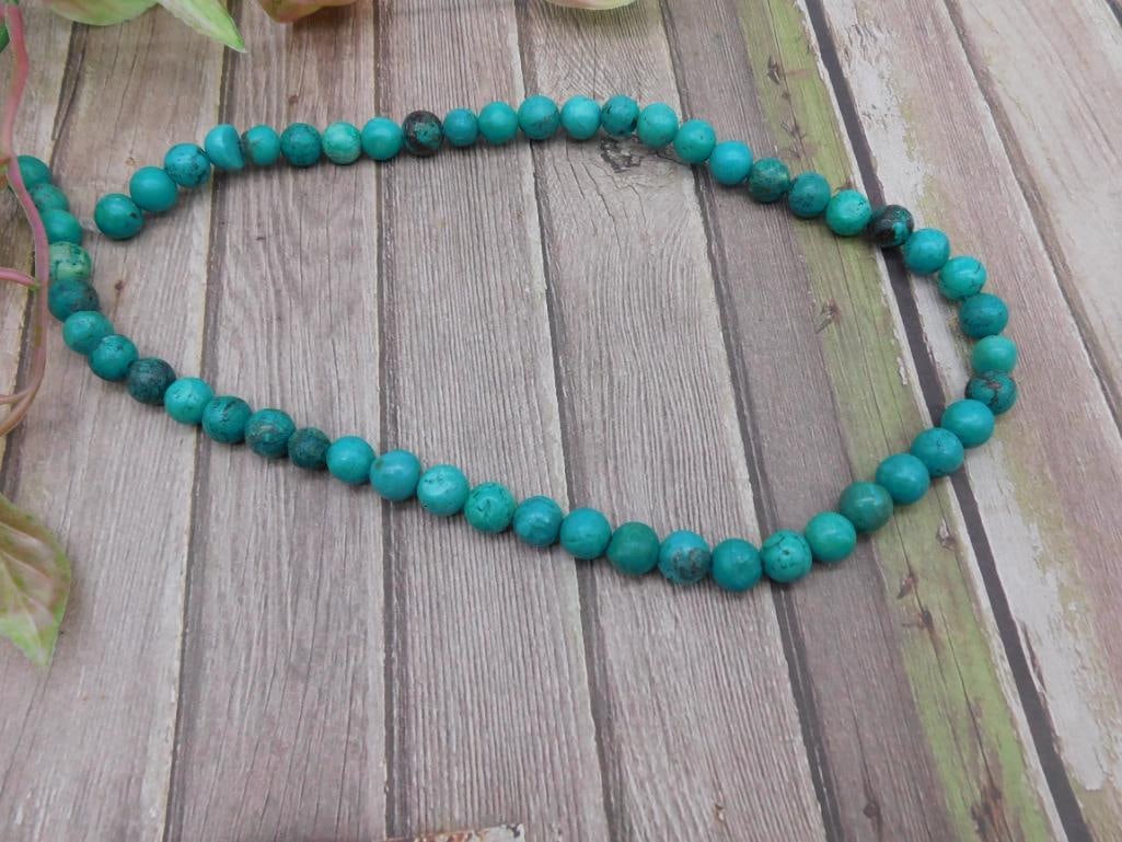 Strand of Turquoise Beaded Necklace: This lot features a strand of turquoise beads, neatly strung together to form a necklace. The beads are consistent in size and exhibit the characteristic color and patterns of turquoise. The necklace