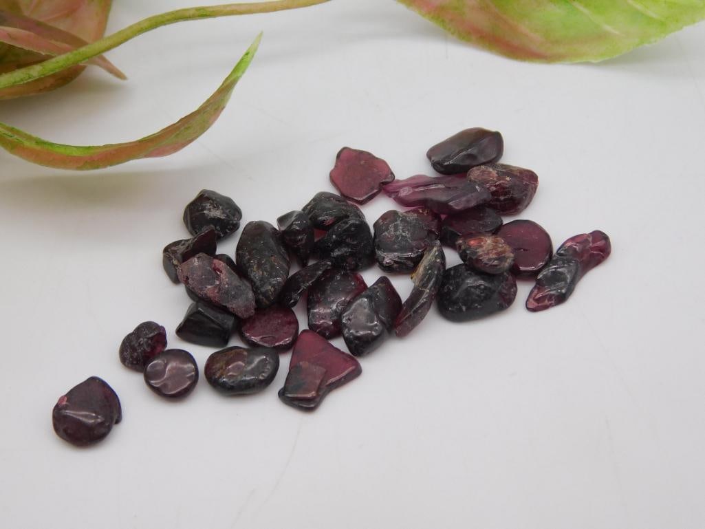 Small Lot of Rough Garnet Stones, 12 Grams: A lot consisting of rough, unpolished garnet stones in various sizes and shapes. Total weight of the lot is 12 grams. Perfect for collectors or gemstone enthusiasts. Comes from a 2024 Rock Auction, as