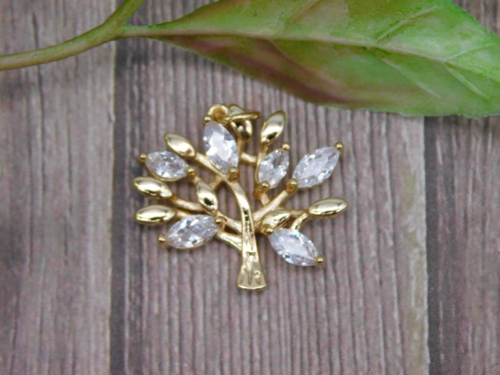 Gold-Tone Tree Pendant with Clear Stone Accents: Gold-tone metal tree-shaped pendant adorned with clear, marquise-shaped stone accents. Approximate size shown against ruler for scale. Ideal as a pendant or for craft/jewelry projects. Weight and addi