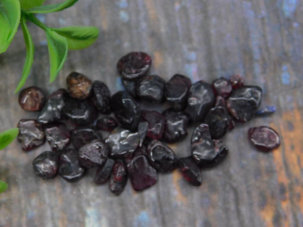 Polished Dark Red Garnet Gemstone Lot: Lot of polished dark red garnet gemstones. Includes multiple irregularly shaped garnet pieces with a rich and deep red hue. Ideal for crafting, jewelry making, or collecting. Stones have a smooth fini