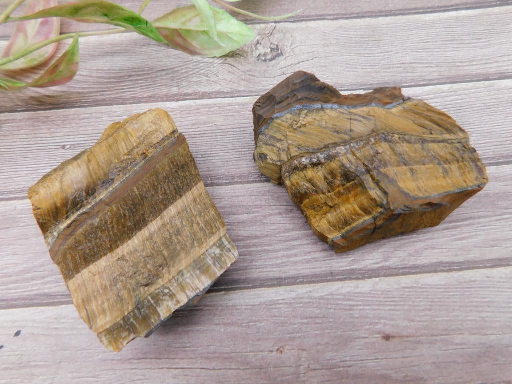 Two Raw Tiger?s Eye Stone Specimens ? 150 Grams Total Weight: Two raw pieces of Tiger's Eye stone, with both specimens showcasing the characteristic golden-brown and dark striping. Total weight is 150 grams as indicated. Ideal for crystal collectors or lapidary 
