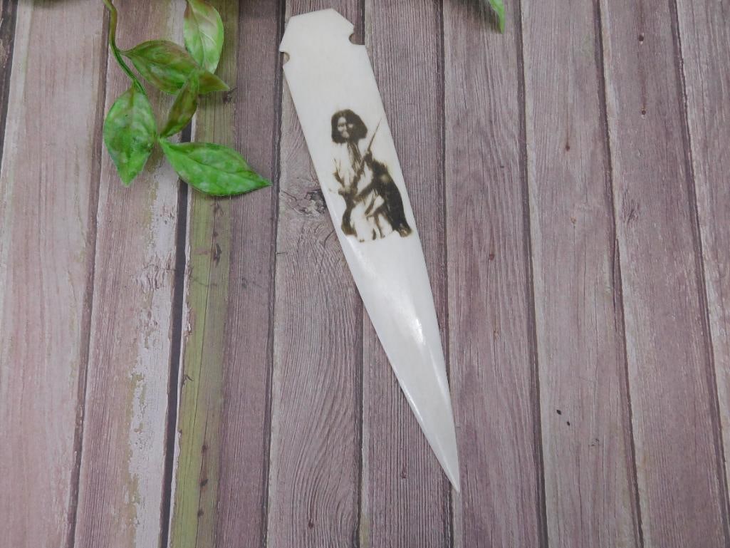 Decorative Polished Bone Blade with Native American-Inspired Artwork: Decorative polished bone blade featuring an engraved image of a seated Native American figure. Blade design includes tapering edges and pointed tip. Suitable for decorative display or collection.