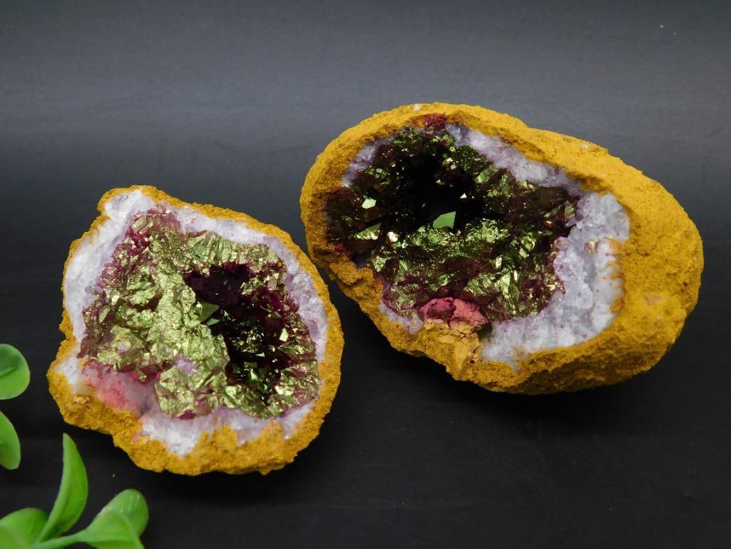 Split Geode With Vibrant Green and Purple Crystal Formations: Split geode featuring a vibrant crystal interior with green and purple tones, outer layer showcasing a textured gold-hued surface, and smooth quartz formations. Geode halves reveal natural crystalline