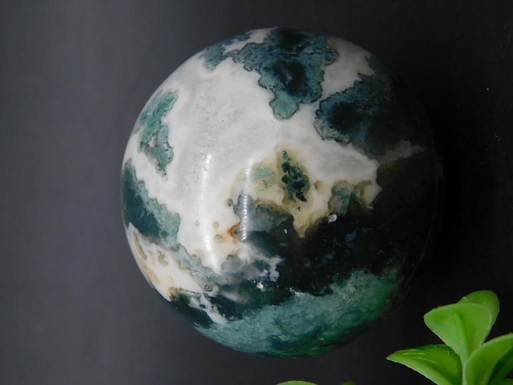 Polished Moss Agate Sphere With Distinctive Green and White Patterns: Polished moss agate sphere displaying varied green and white patterns. Suitable for display or collection. Weighs approximately 154 grams. Accompanied by a ruler for scale in the image.