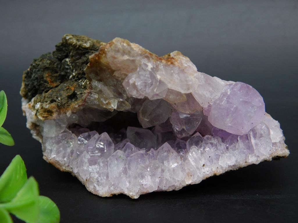 Natural Amethyst Crystal Cluster with Rough Rock Matrix: Natural amethyst quartz crystal cluster featuring a vibrant purple hue, set within a rough rock matrix. Weighs approximately 129 grams. Ideal for collectors or display.