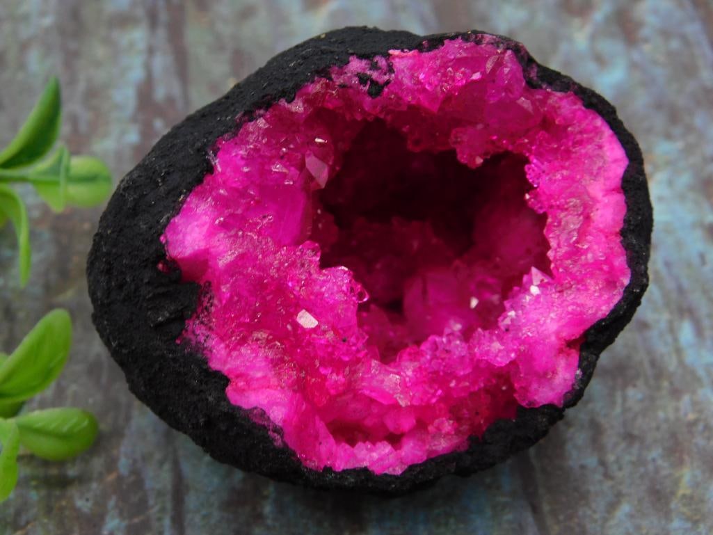 Bright Pink Geode With Crystalline Interior Rock Stone Lapidary Specimen: A vibrant pink geode with a natural crystalline interior. Approximate weight: 146 grams, as indicated. The exterior is dark and textured, contrasting the bright colored crystals inside. Includes a ref