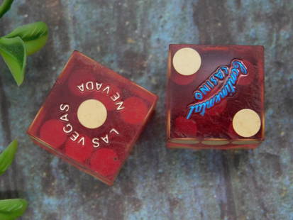 Pair of Las Vegas Casino Dice with Branding: A pair of dice from the renowned Continental Casino in Las Vegas, Nevada. The dice are red with gold-colored pips and feature 'Continental Casino' branding. The sides include 'Las Vegas Nevada' letter