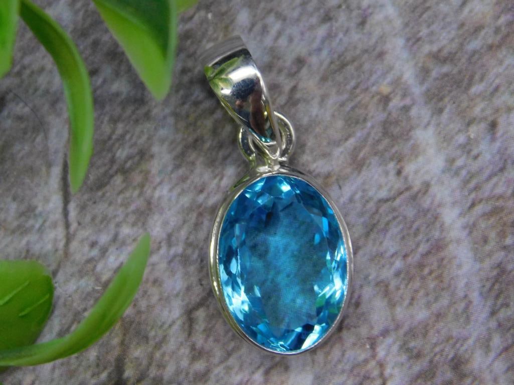 Blue Topaz and Sterling Silver Oval Pendant: This pendant features a brilliant blue topaz stone in an oval cut, set in sterling silver. The stone weighs approximately 3 grams, providing a lightweight and elegant accessory. The shiny sterling sil