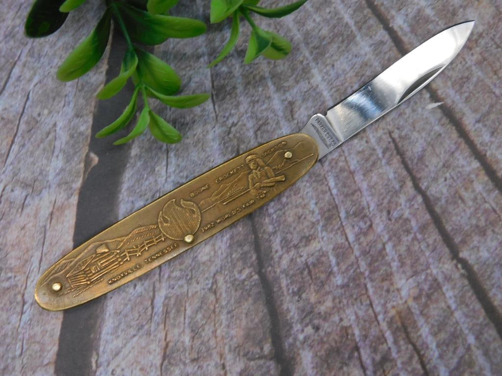 Parker Cut. Co. Brass Handle Collectable Folding Knife: Collectible folding knife featuring a brass handle with detailed engravings, including Davy Crockett and Andrew Jackson motifs. Blade marked 'Parker Cut. Co.' Includes ruler for scale in the photograp