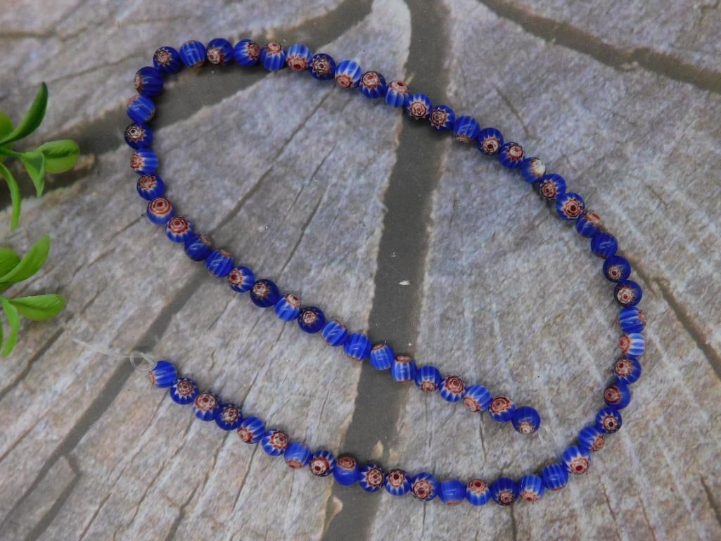 African Trade Beads ROCK STONE LAPIDARY SPECIMEN: This is a strand of blue chevron beads featuring red accents. Each bead is meticulously crafted and consistent in design. The beads are strung together, ideal for collectors or jewelry-making enthusia