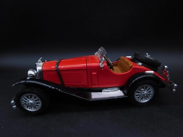 Red Die-Cast Model of a Classic Convertible Car by Bburago