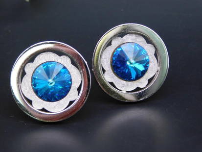 Pair of Silver-Tone Cufflinks With Blue Crystal Accents: This is a pair of silver-tone cufflinks featuring vibrant blue crystal accents. The circular design includes a textured silver-tone backdrop, enhancing the central crystal's brilliance. T-back closure