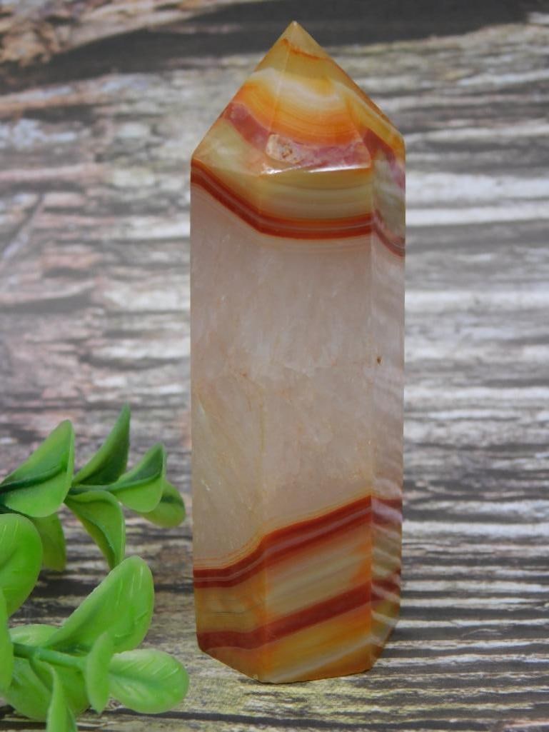 Banded Agate Point With Warm Tones: Beautiful banded agate point featuring warm tones of orange, red, and cream. The point is shaped into a double-terminated design, ideal for display or collection. Dimensions are visible next to a rule