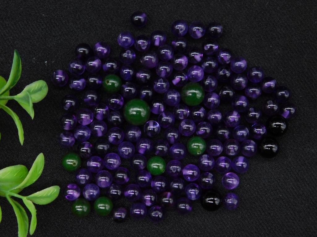 Lot of Green and Purple Beads, 36 Grams: A collection of green and purple beads with a total weight of 36 grams. Includes a variety of bead sizes, primarily spherical, as shown in the images. Ideal for crafting or other creative uses. Coin a