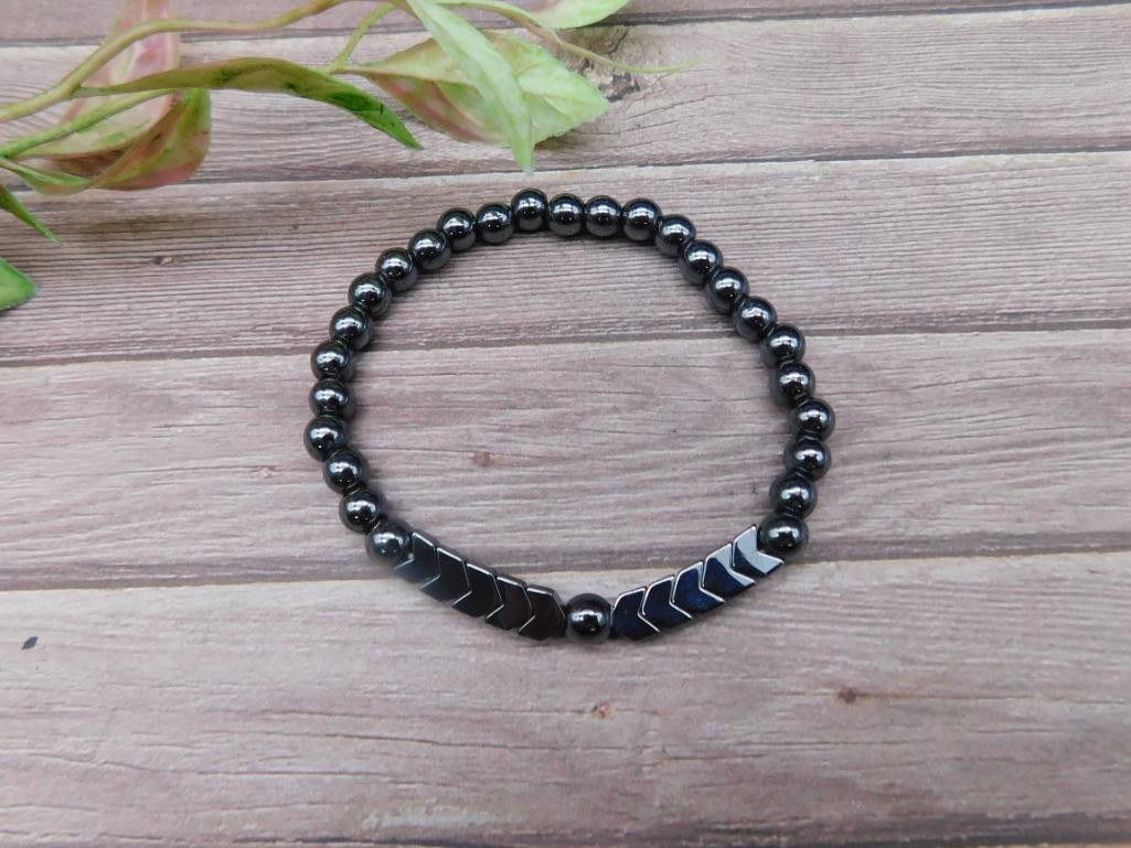 Black Hematite Beaded Bracelet With Chevron Accents: This black hematite bracelet features a series of round beads complemented by chevron-shaped accents. Designed with an elastic band for a comfortable fit, this bracelet is ready-to-wear and versatile.