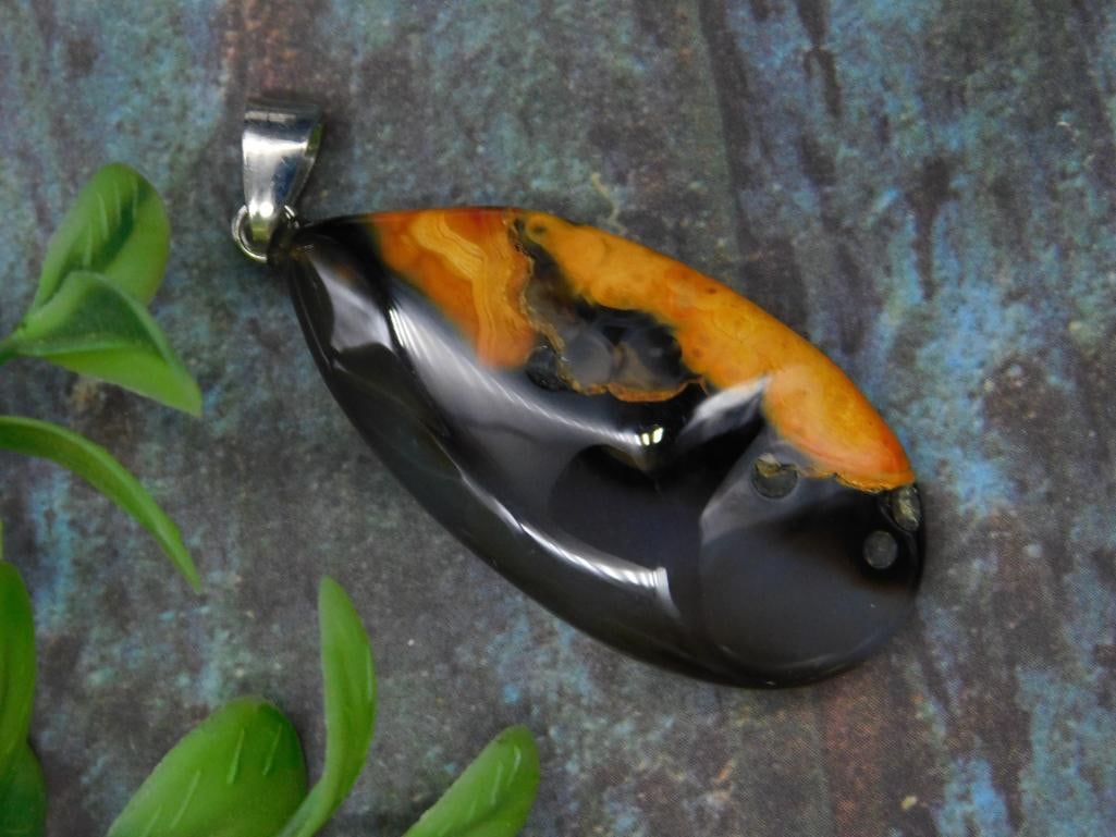 Eclipse Agate Pendant Rock Stone Lapidary Specimen: Teardrop-shaped pendant featuring polished black and orange patterns. Made from a natural stone with a hole drilled for attaching to the included metal bail. Measures relatively small, as shown next t