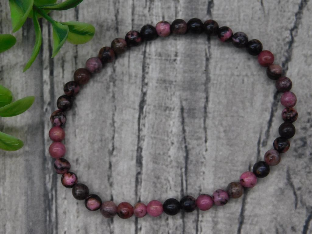 Beaded Rhodonite Stretch Bracelet: Beaded stretch bracelet made using round rhodonite stones. Features predominantly pink and black tones. Stretchable design for ease of wear. The coin and auction card are shown for size reference.