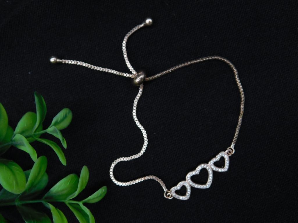 Adjustable Heart Design Bracelet with Crystal Accents: Beautiful adjustable bracelet featuring three interlinked heart motifs adorned with crystal accents. The bracelet includes an adjustable slider clasp for a custom fit. Ideal for pairing with any outfi