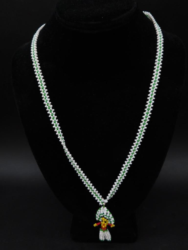 Beaded Multicolor Bird-Themed Necklace: This piece is a handcrafted necklace featuring a beaded bird pendant. The beads are arranged in white, green, yellow, and red to form a colorful parrot motif. The necklace features a consistent bead s