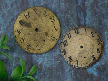 Two Metal Clock Faces with Numeric Markings